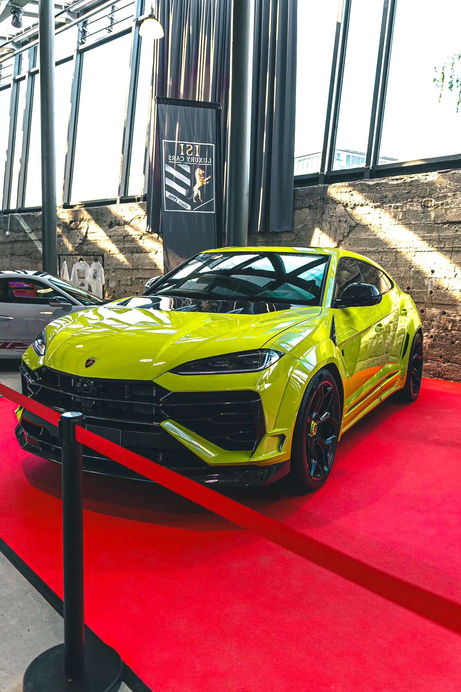 Limettengrüner Lamborghini Urus auf dem roten Teppich, Hochformat