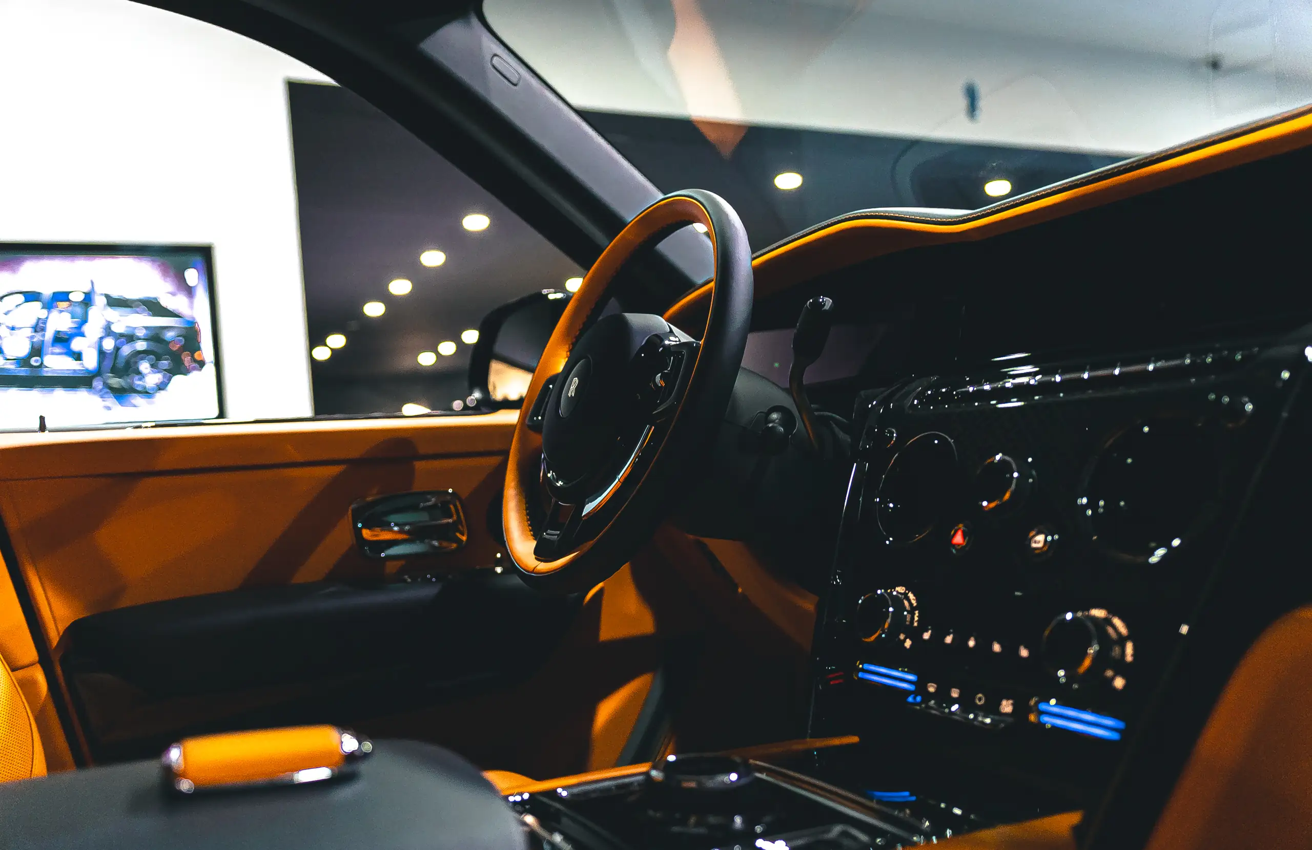 Interieur eines Rolls-Royce Cullinan in Orange mit Lenkrad und Armaturen