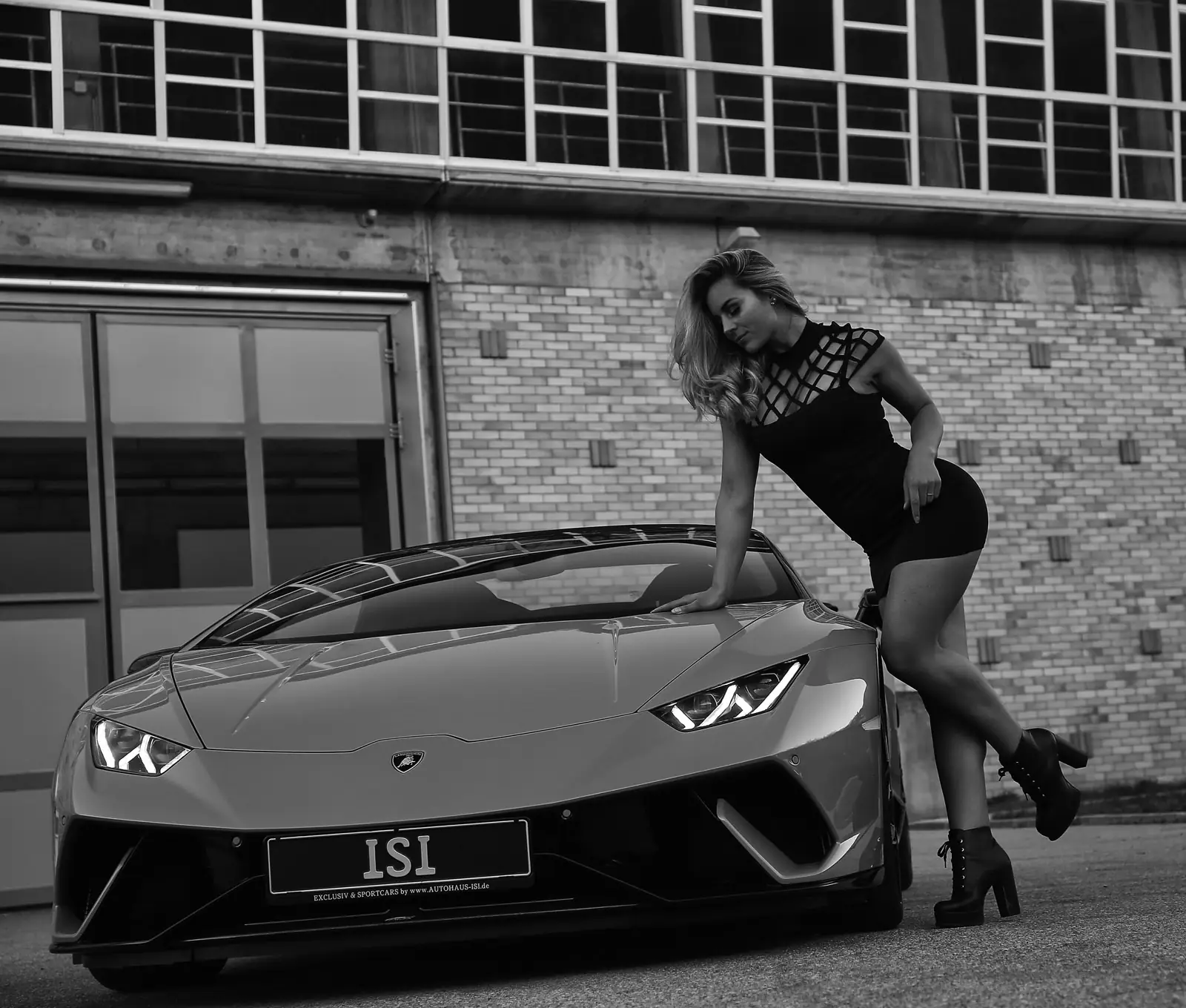 Modelshooting mit einem Lamborghini Huracán Performante vor einer Ziegelfassade, Schwarz-Weiß-Aufnahme