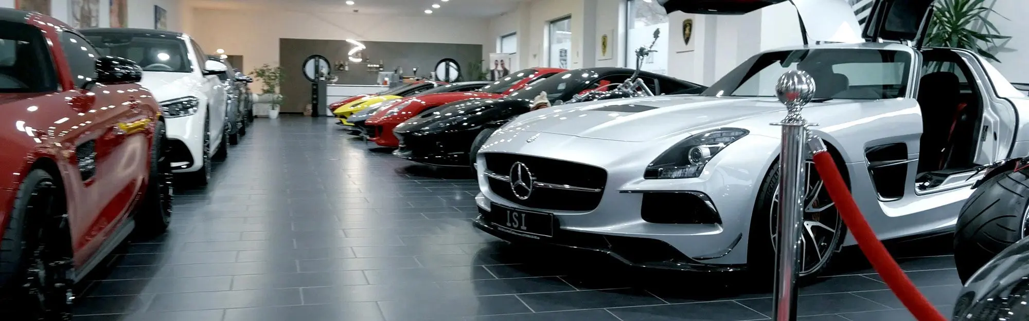 Fahrzeugreihe im Showroom mit Mercedes SLS AMG im Vordergrund
